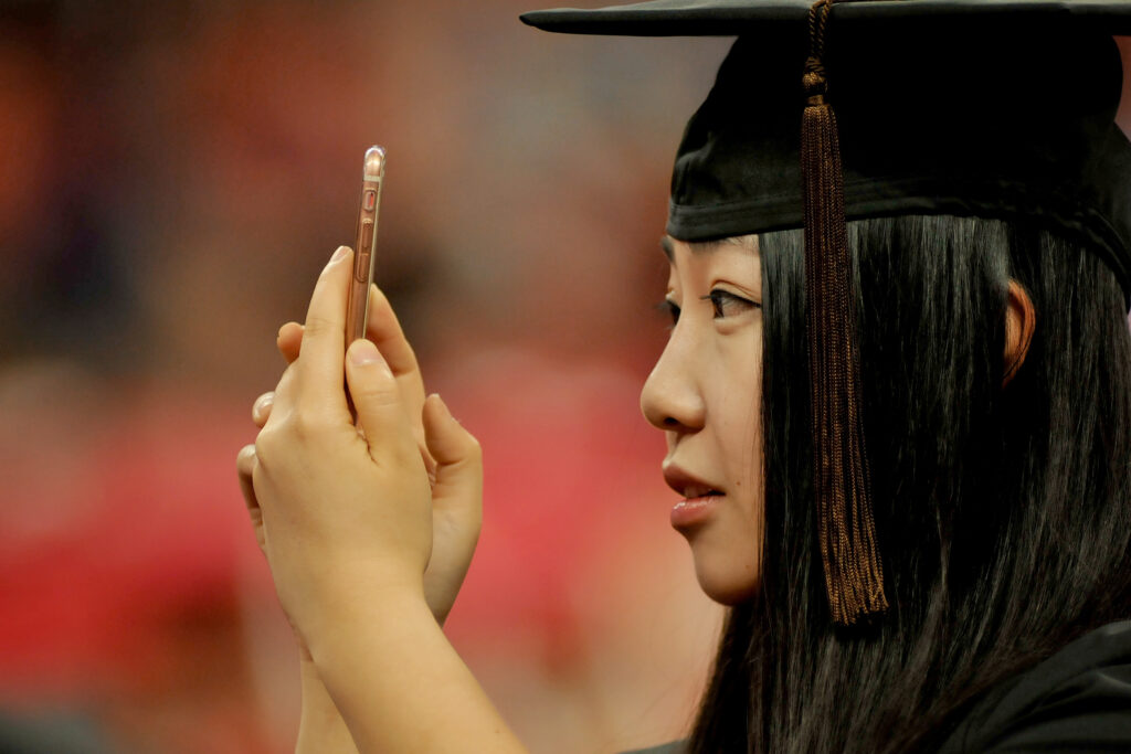 A recent graduate poses for photos at the Court of North Carolina. (Photo by Marc Hall)