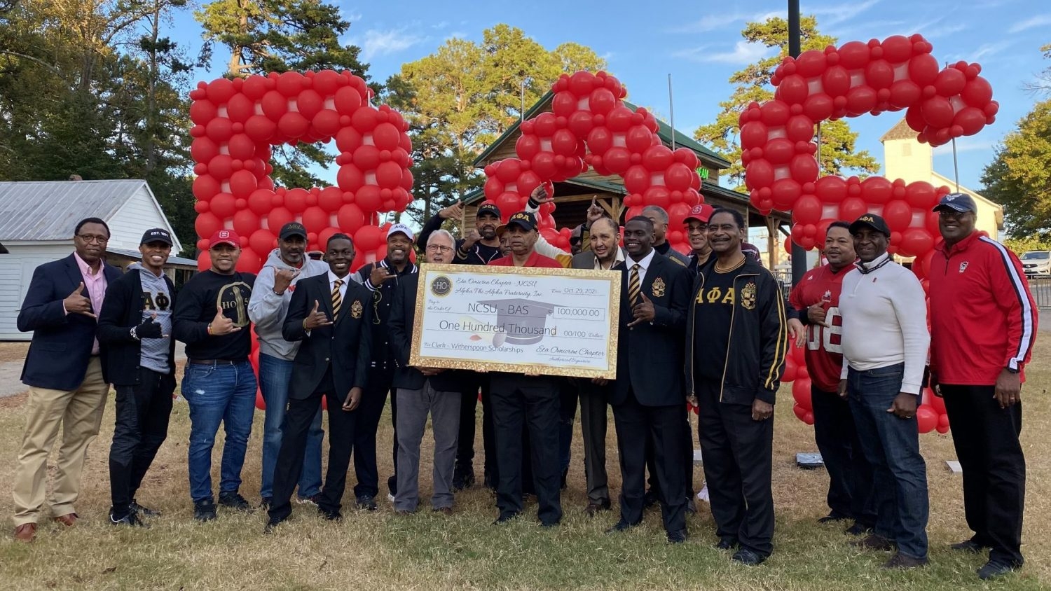 members of Alpha Phi Alpha present their scholarship to Chancellor Woodson