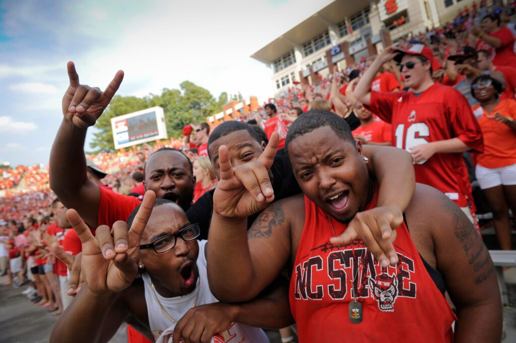 Fans cheer on the wolfpack during a football game.