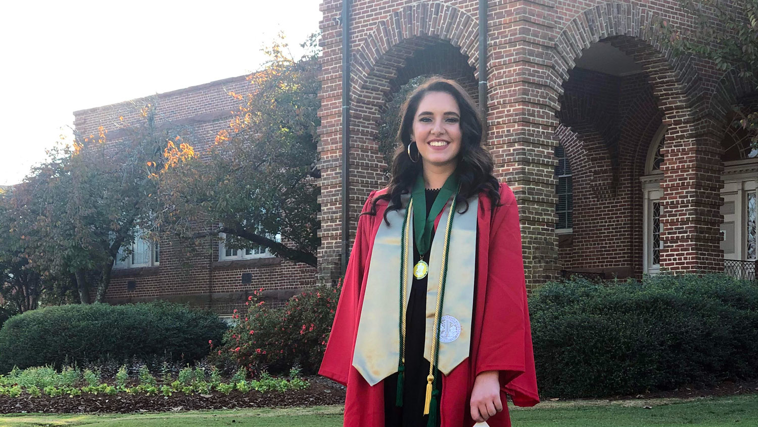 Sarah Maddry wearing her gown and other graduation regalia.