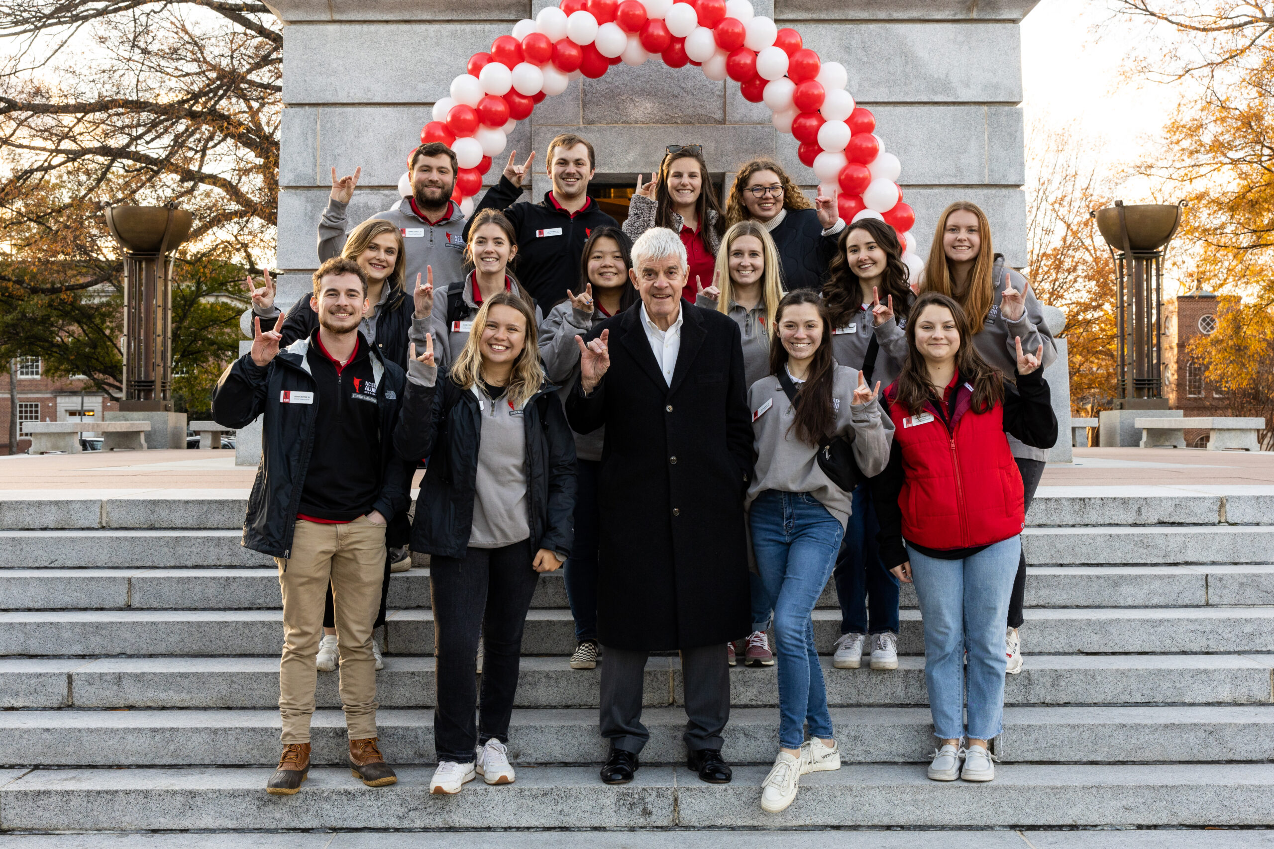 student alumni association members in front of the belltower