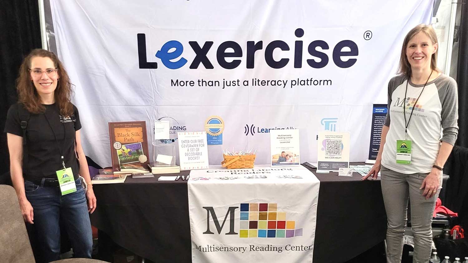 Two Lexercise employees pose in front of their booth.