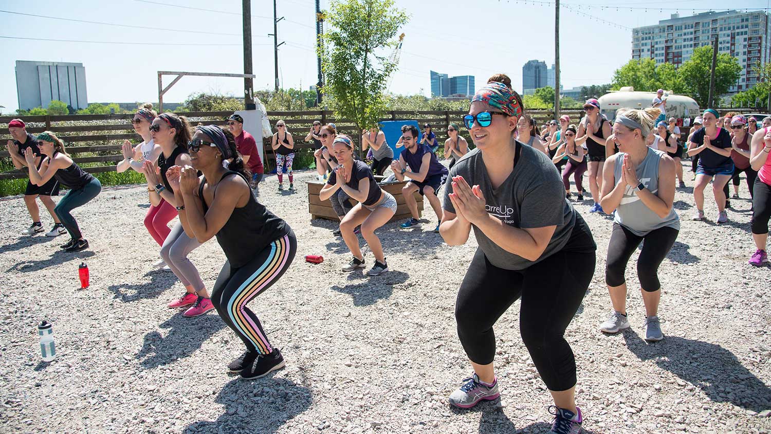 Men and women of Current Wellness get in a workout at a gravel lot in Raleigh.