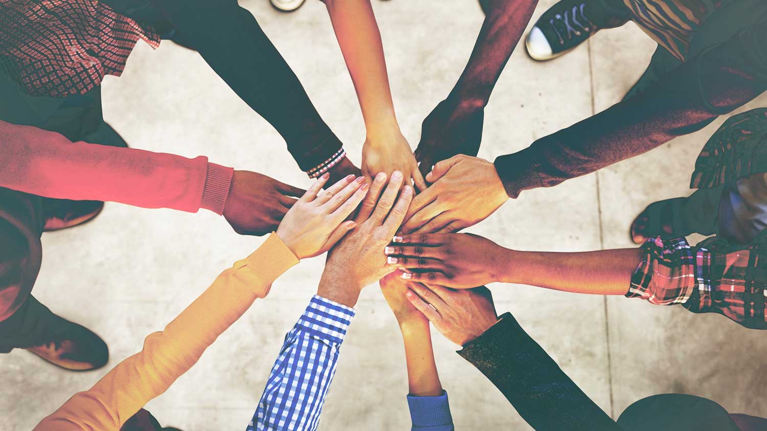 A group touches hands in a circle.